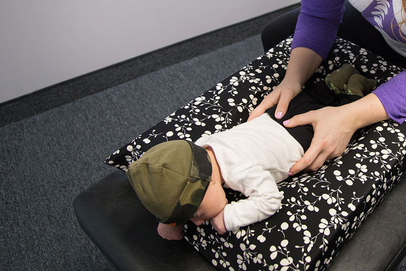 Infant Facedown pediatric chiropractic adjustment with Chiropractor in Rochester NY