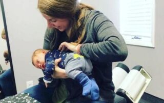 Pediatric chiropractor holding baby