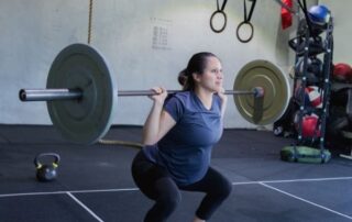 Pregnant woman squatting with weights