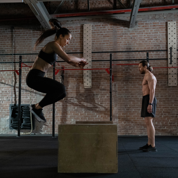 Man and woman doing box jumps
