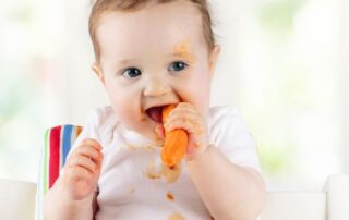 Baby eating a carrot.
