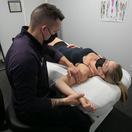 Male massage therapist giving female athlete a massage.