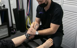 Male chiropractor mobilizing a dancer's foot.