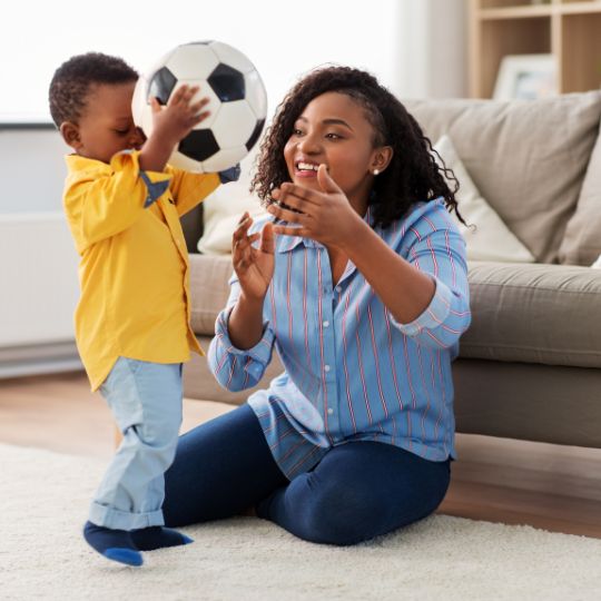 Mother and child playing with a soccer ball.