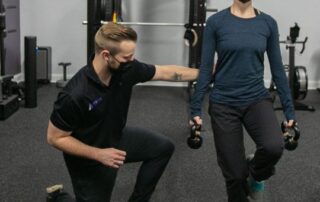 Male chiropractor taking female dancer through rehab exercises.