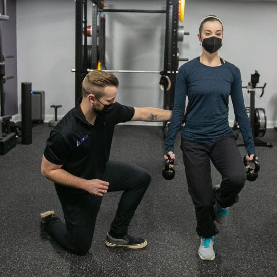 Male chiropractor taking female dancer through rehab exercises.