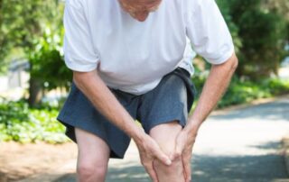 Caucasian, male, senior citizen holding his knee in pain.