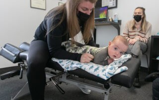 Female chiropractor adjusting an infant.