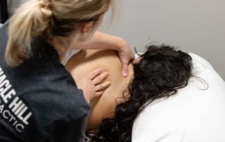 blonde, caucasian woman massaging a brunette, female client.