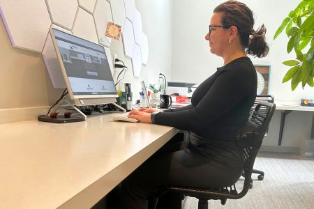 female employee sitting at a desk working on a computer