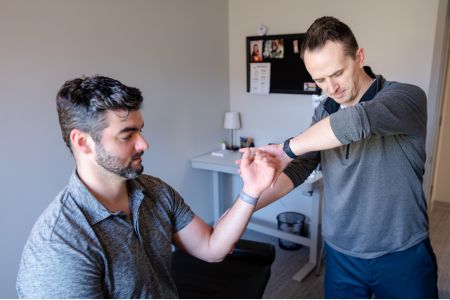 Male chiropractor working on male patient's wrist